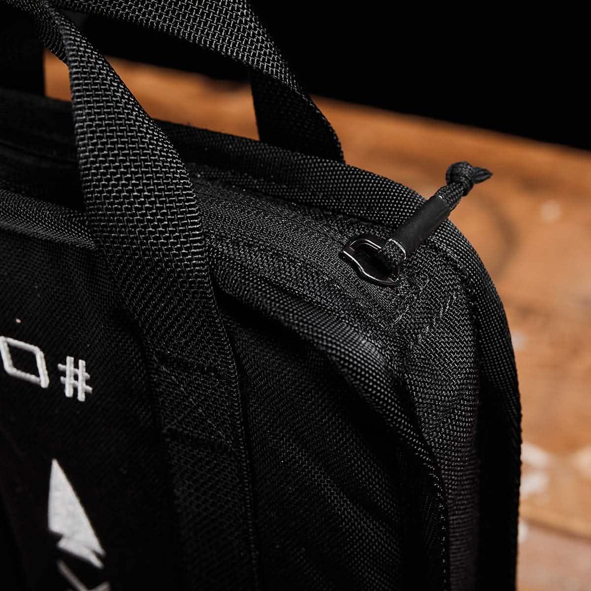 Close-up of GORUCK black ruck plate carrier handle and zipper on a wooden surface