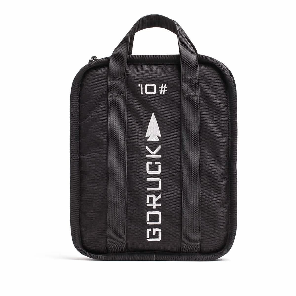 A rugged-textured Rucker bag in black from GORUCK, featuring two handles and adorned with GORUCK and 10 printed in white alongside an arrow design. The front showcases vertical stitching lines, and it comes with a lifetime guarantee for ultimate peace of mind.