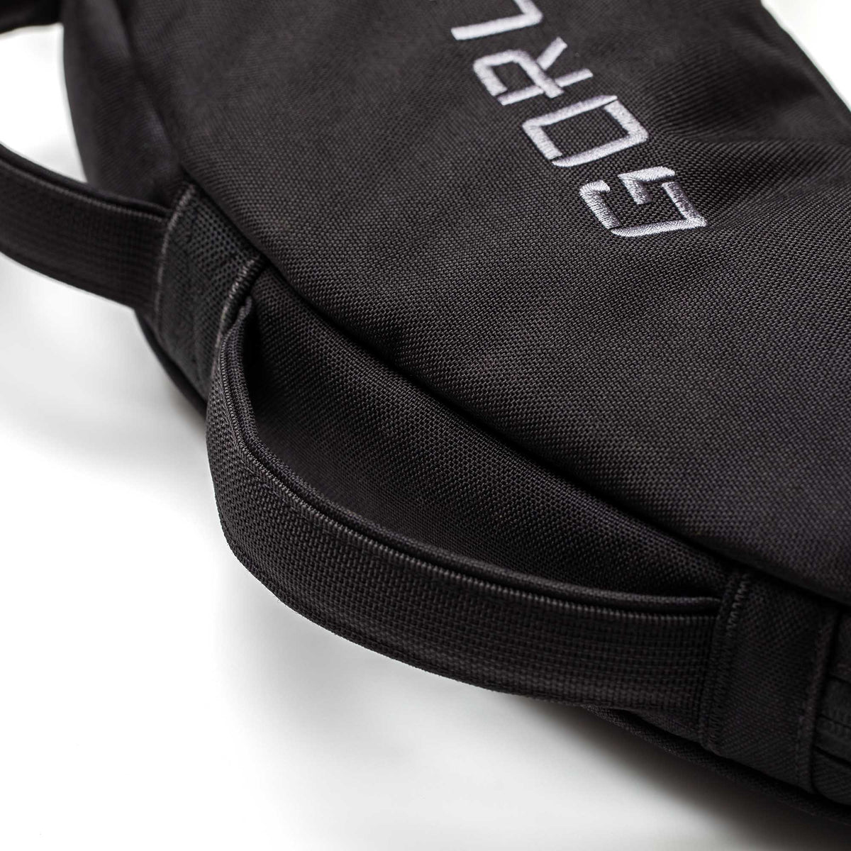 Close-up of a black Bulgarian Sandbag with stitched handles and partial white embroidered text.