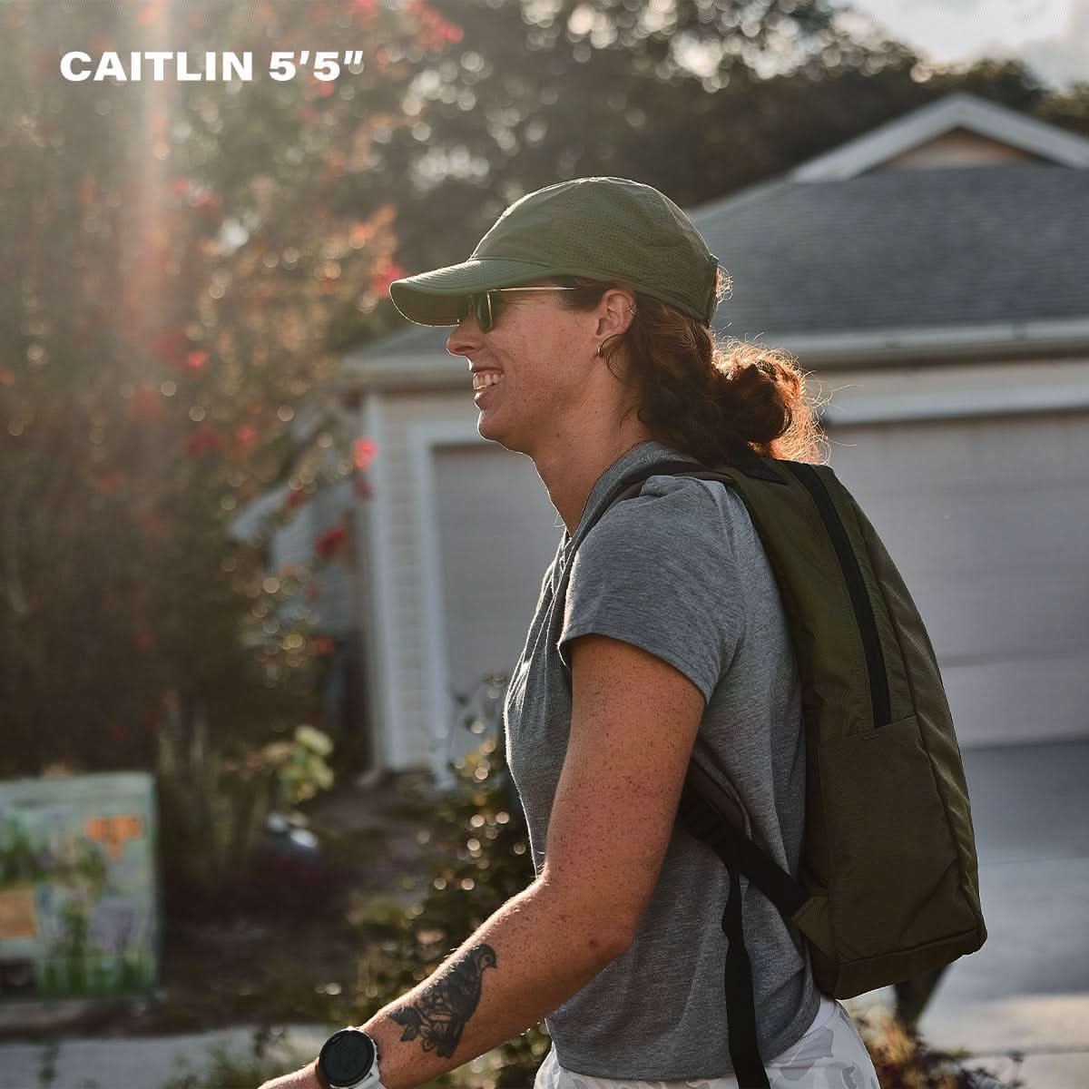 Woman wearing GORUCK rucksack outdoors, smiling, in casual gear, 5'5