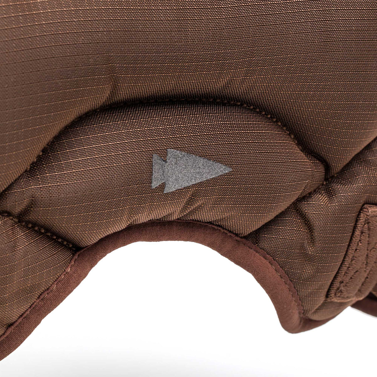 Close-up of the brown padded fabric with a gray arrow symbol and visible stitching on the Spy Ruck | Women's Weighted Vest.